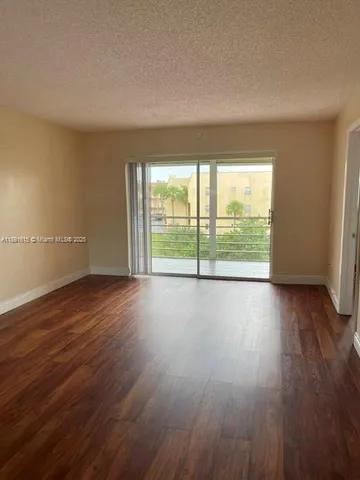 a view of a room with wooden floor and large window