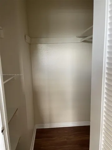 a view of a room that has wooden floor and a window