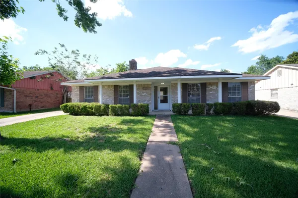 a front view of a house with a yard and potted plants