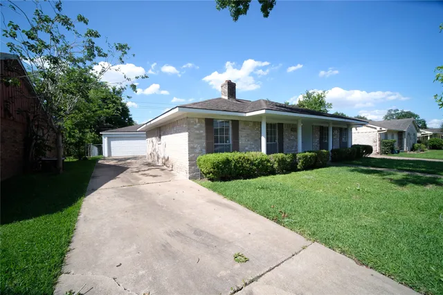 a front view of a house with a yard and trees