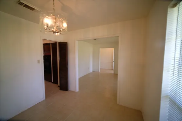 en view of a hallway with chandelier and glass door