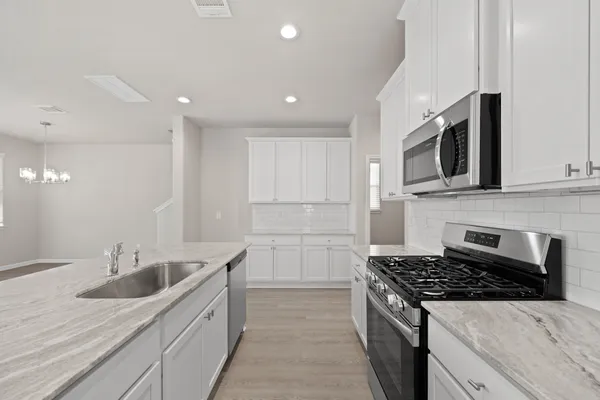 a kitchen with stainless steel appliances kitchen island granite countertop a sink and a stove