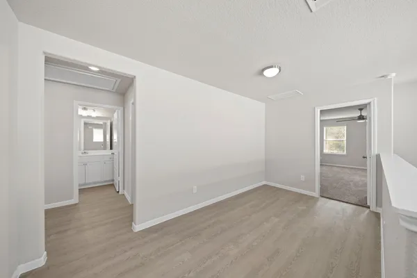a view of an empty room with closet and a window