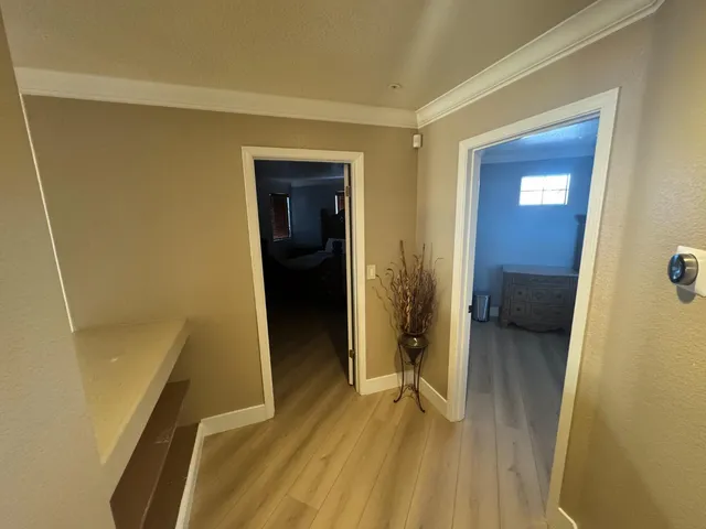 a view of a hallway with wooden floor and a living room