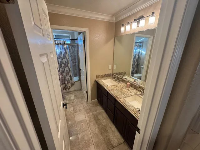 a bathroom with a granite countertop sink a mirror and shower