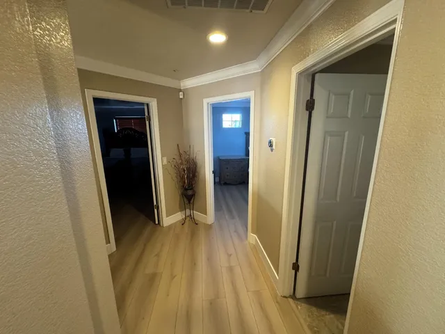 a view of a hallway with wooden floor and staircase