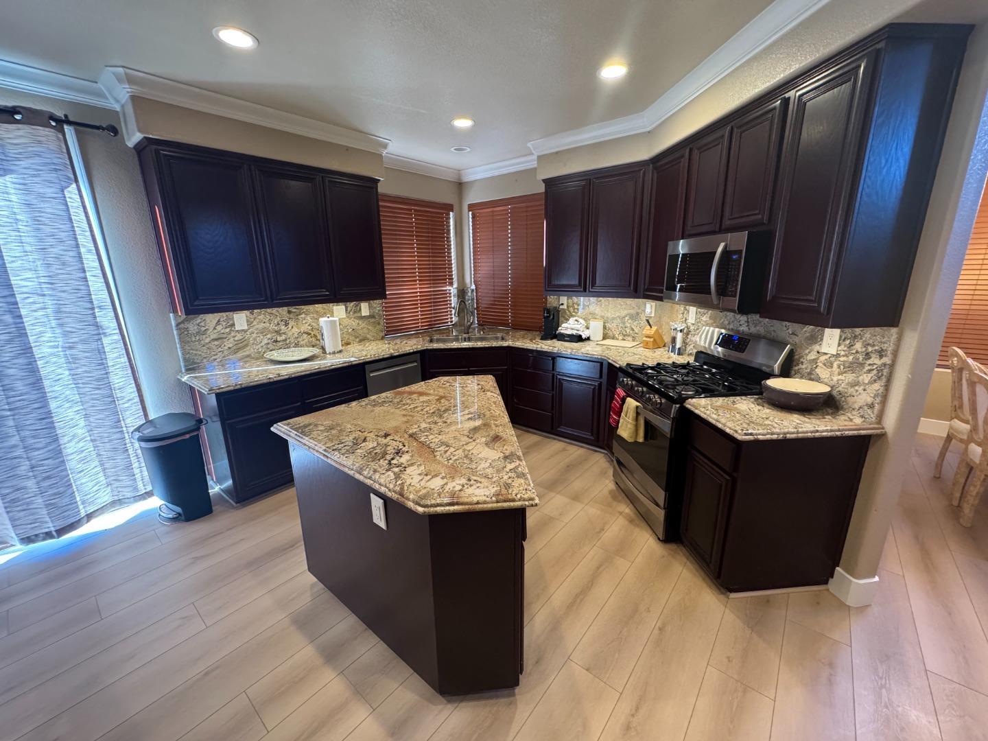 10 Rhine Circle Salinas, CA 93906 - Photo 21 of 50 a kitchen with stainless steel appliances granite countertop a stove a sink dishwasher and a refrigerator with wooden floor