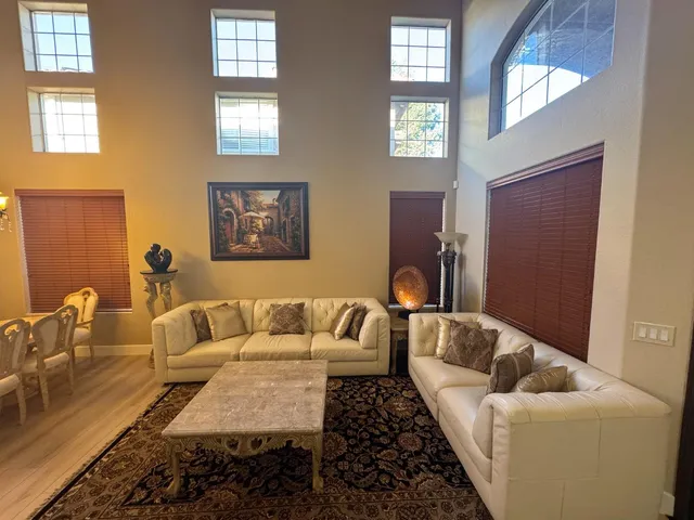 a living room with furniture and stairs with wooden floor