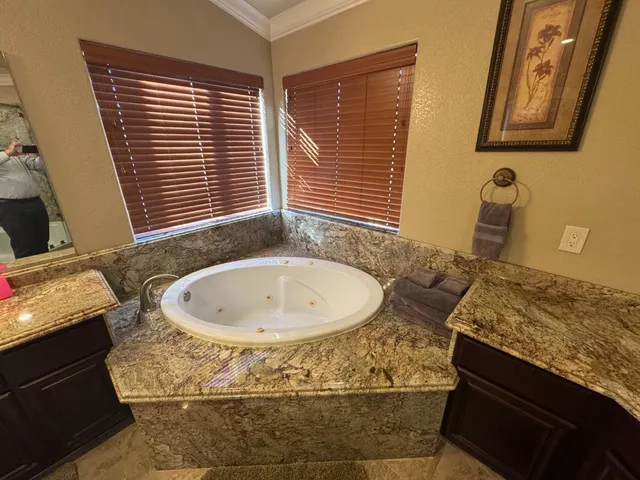 a spacious bathroom with a granite countertop tub sink and mirror