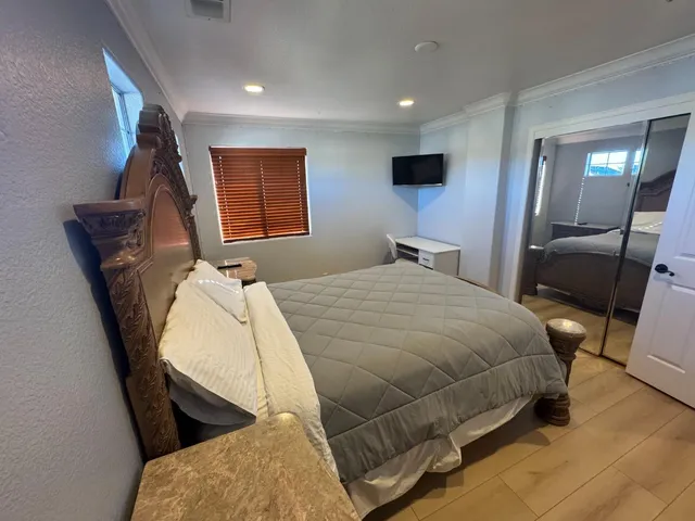 a bedroom with a bed and wooden floor