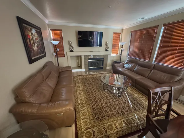 a living room with furniture a flat screen tv and a fireplace