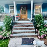 a view of a house with potted plants and a flower garden