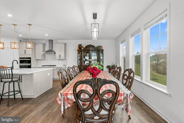 a view of a dining room and livingroom with furniture wooden floor a chandelier