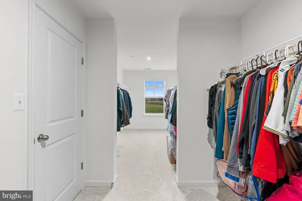 a view of a hallway with wooden floor and a bathroom