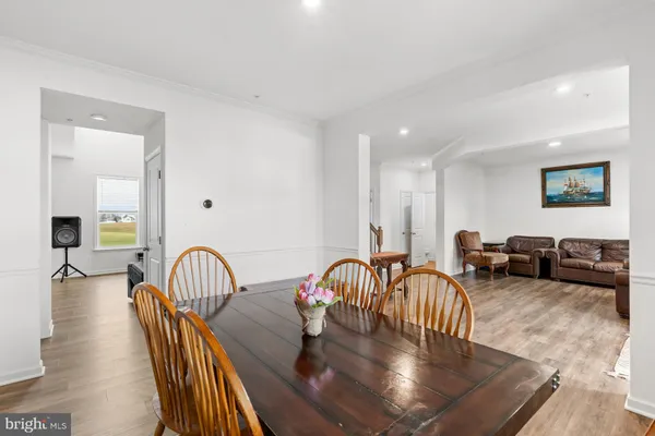a view of a a dining room with furniture window and wooden floor