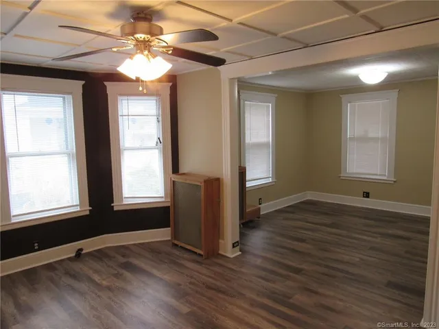 an empty room with wooden floor and windows