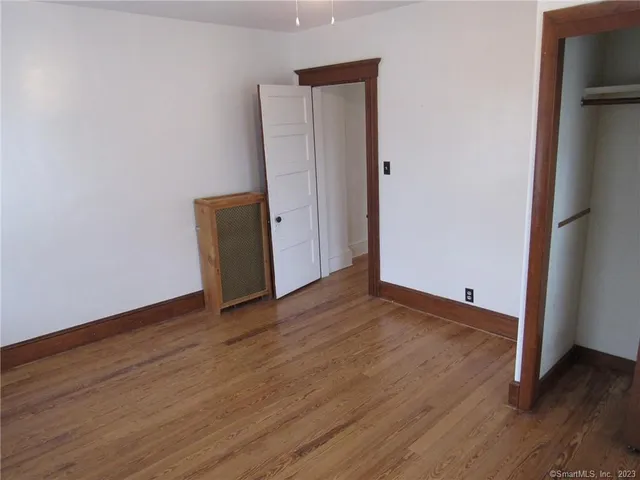 an empty room with wooden floor and closet