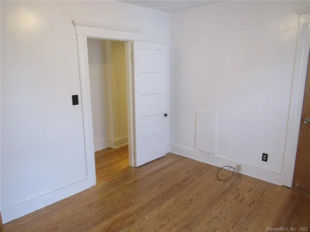 an empty room with wooden floor and entrance
