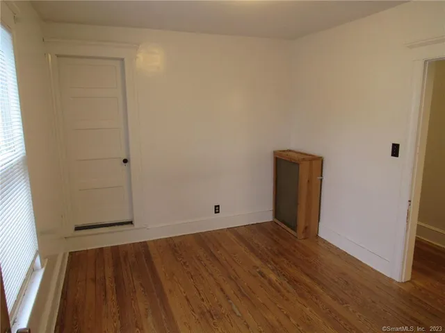 an empty room with wooden floor and entrance