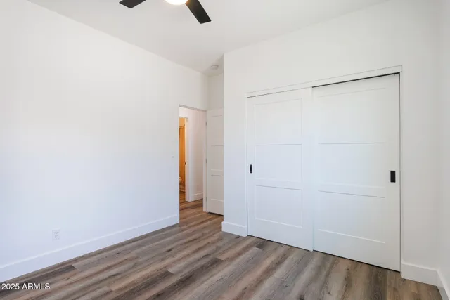 an empty room with closet and wooden floor