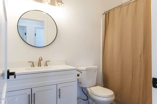 a bathroom with a sink a mirror a toilet and a mirror