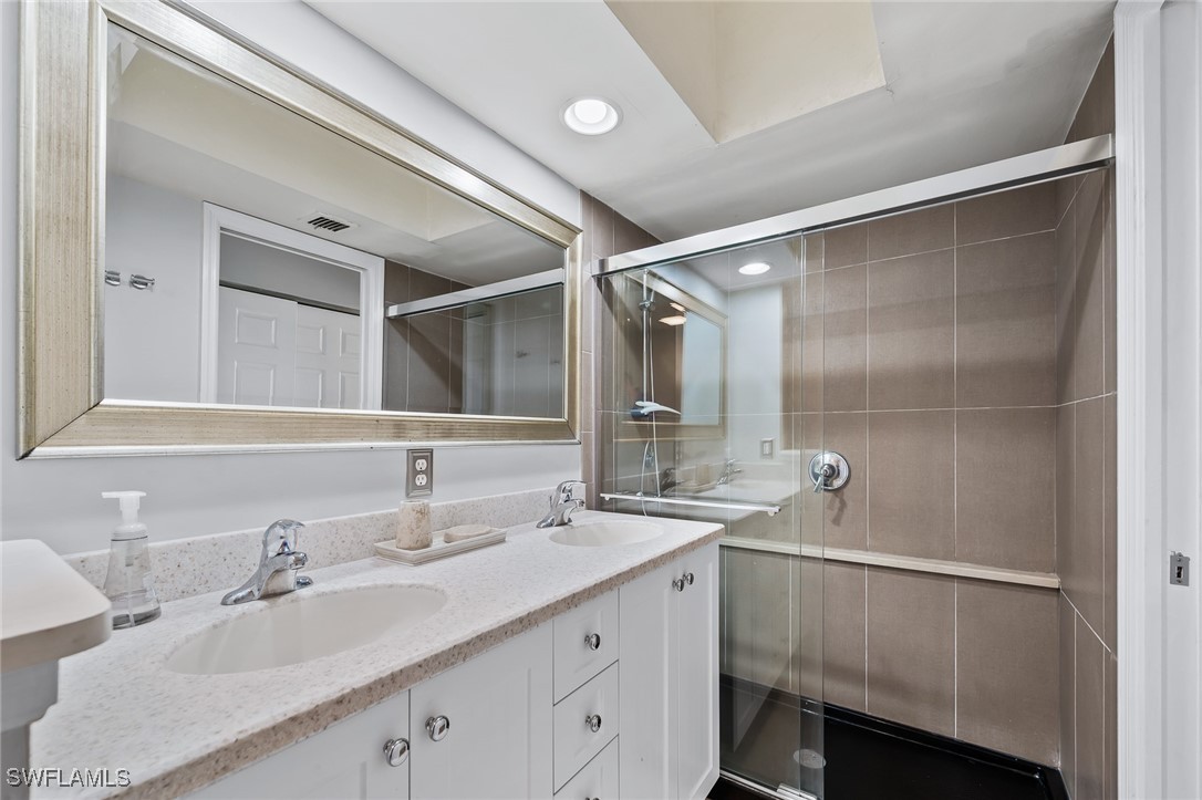 14979 Rivers Edge Court, Unit 223 Fort Myers, FL 33908 - Photo 13 of 18 a bathroom with a double vanity sink and a mirror