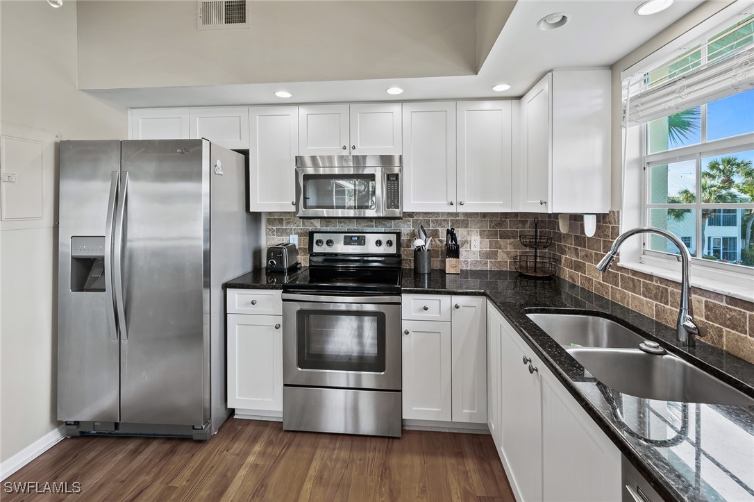 14979 Rivers Edge Court, Unit 223 Fort Myers, FL 33908 - Photo 8 of 18 a kitchen with a refrigerator sink and cabinets