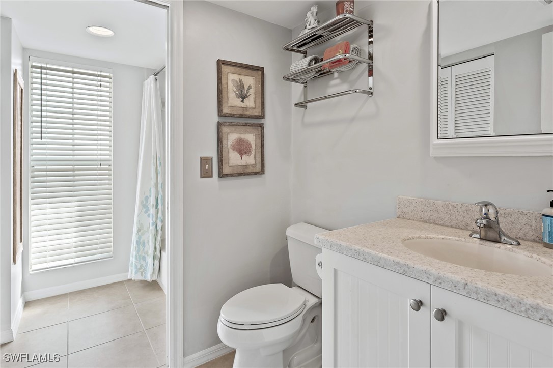 14979 Rivers Edge Court, Unit 223 Fort Myers, FL 33908 - Photo 10 of 18 a bathroom with a granite countertop sink toilet and a mirror
