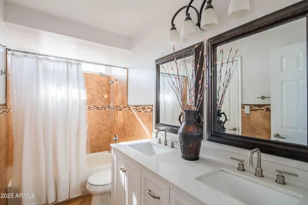 a dining room with chandelier and wooden floor