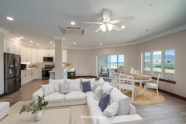 a living room with furniture kitchen view and a large window