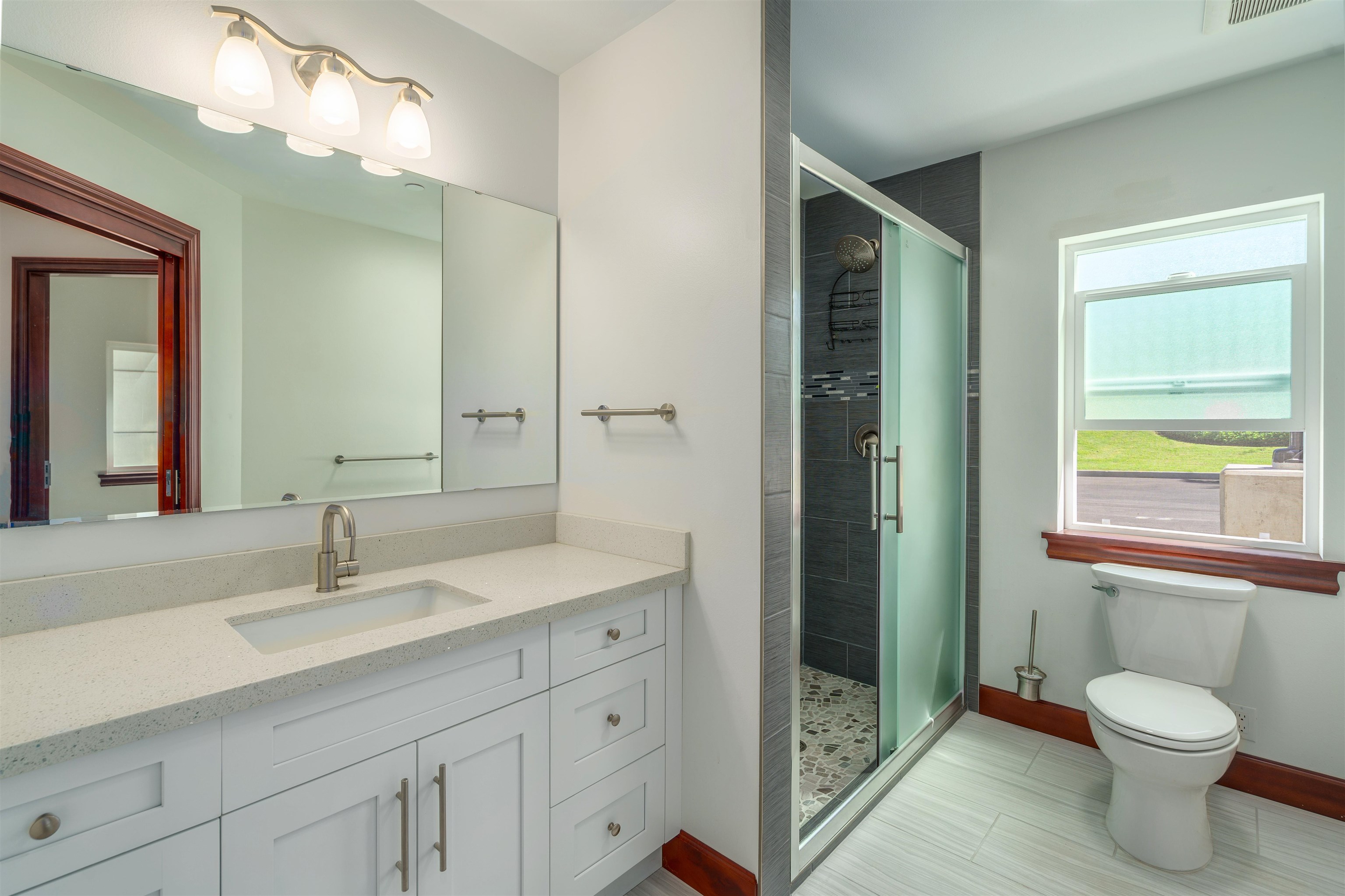 2757 South Kihei Road, Unit 101 Kihei, HI 96753 - Photo 13 of 26 a bathroom with a toilet a sink a vanity a mirror and window