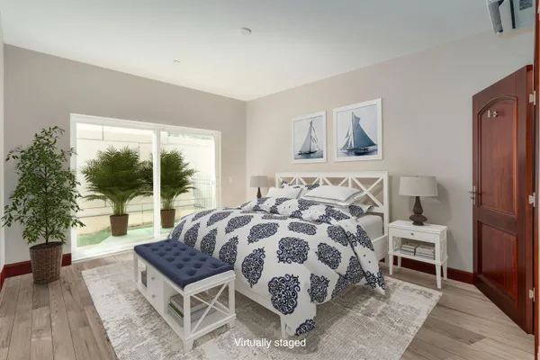 a bedroom with a large bed and a potted plant