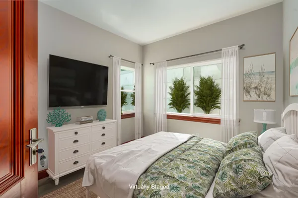 a bedroom with a large bed and a flat tv screen on dresser