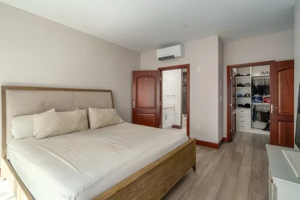 a bedroom with a bed and a wooden floor
