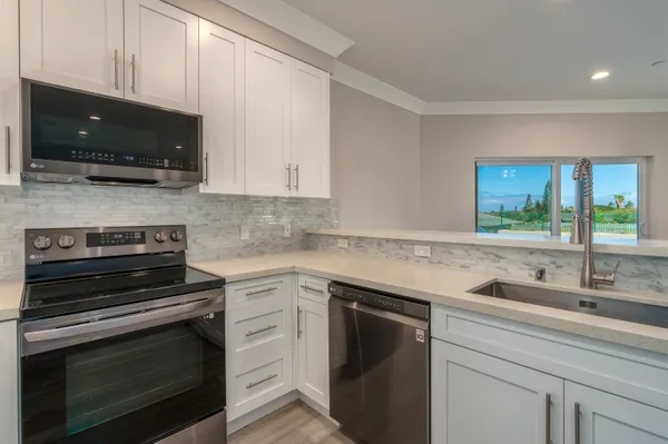 a kitchen with stainless steel appliances granite countertop a sink stove and microwave