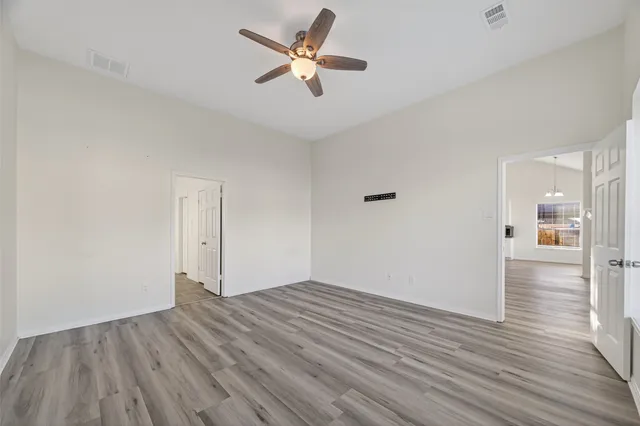 a view of empty room with wooden floor