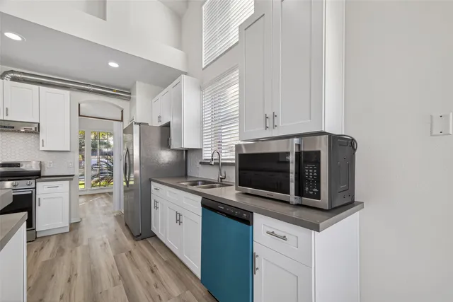 a kitchen with stainless steel appliances a stove microwave and sink