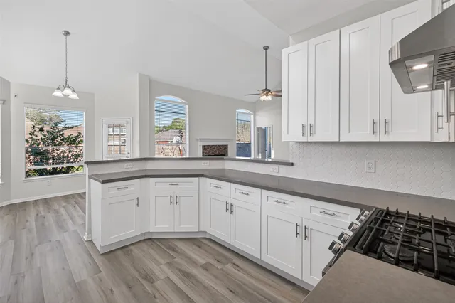 a kitchen with granite countertop white cabinets and white appliances