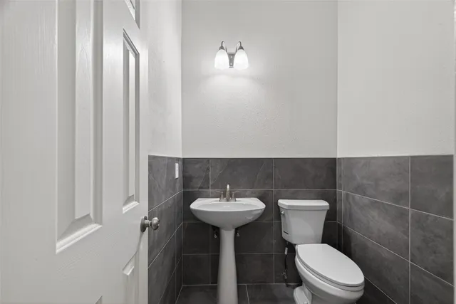 a bathroom with a sink a toilet and a mirror