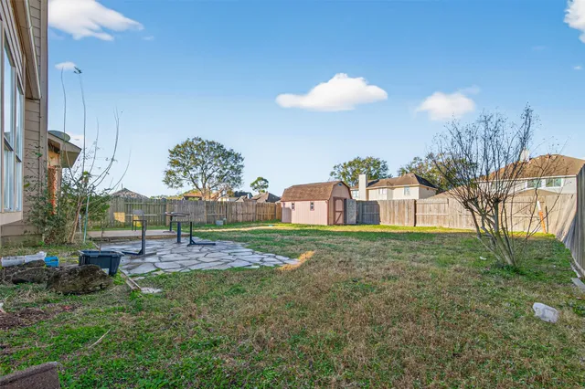 a view of backyard with wooden fence
