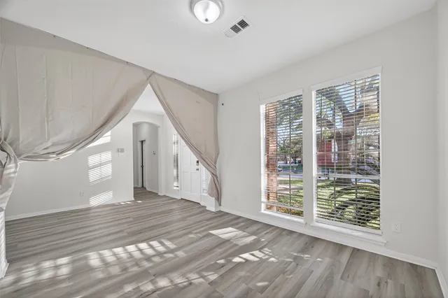 a view of a hallway with wooden floor and windows