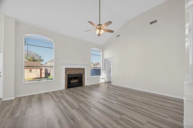 wooden floor fireplace and windows in an empty room
