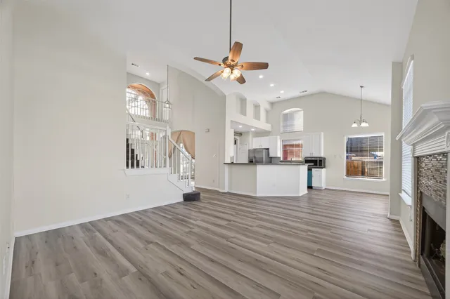 a view of a kitchen with wooden floor and a ceiling fan