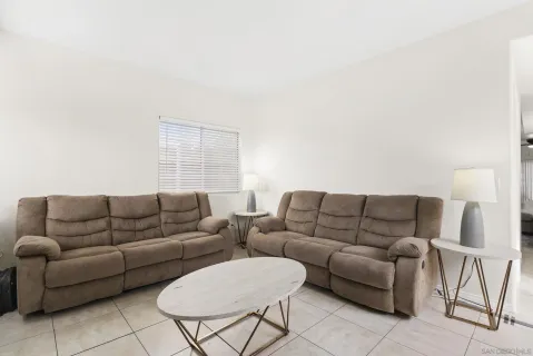 a living room with furniture a couch and white walls
