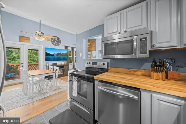 a kitchen with stainless steel appliances granite countertop a stove a sink and a microwave