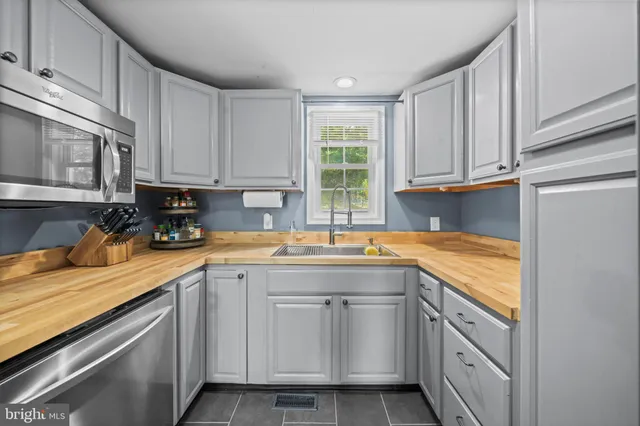 a kitchen with cabinets appliances a sink and a counter top space