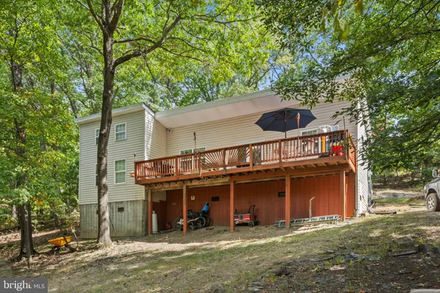 a view of a house with a yard balcony and tree
