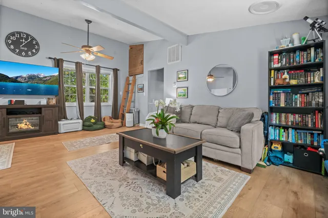 a living room with furniture a bookshelf and a large window