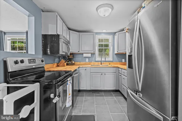a kitchen with stainless steel appliances a sink stove and refrigerator