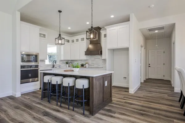 a large kitchen with a table and chairs